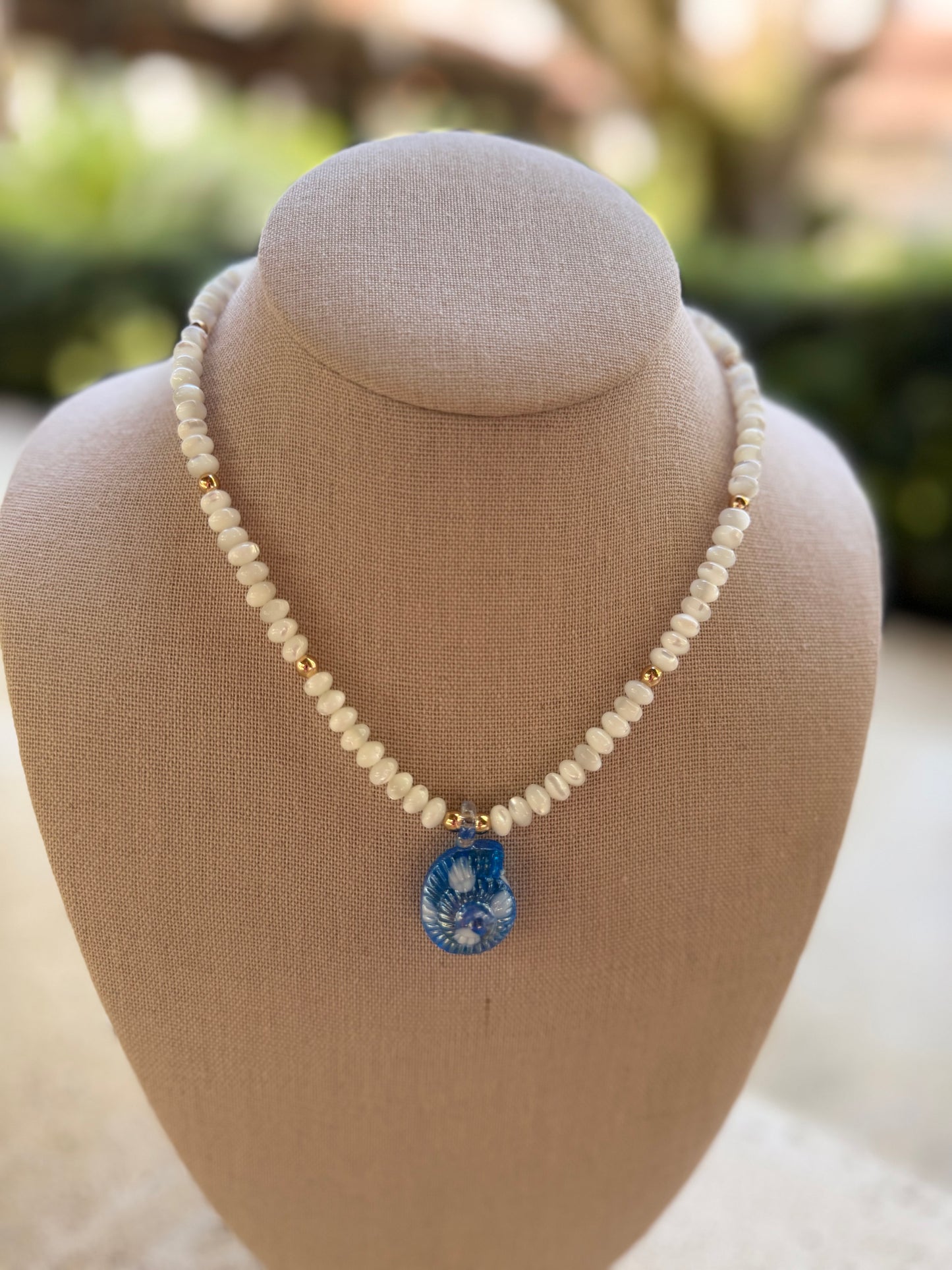 Flock: white mother of pearl with blue nautilus pendant