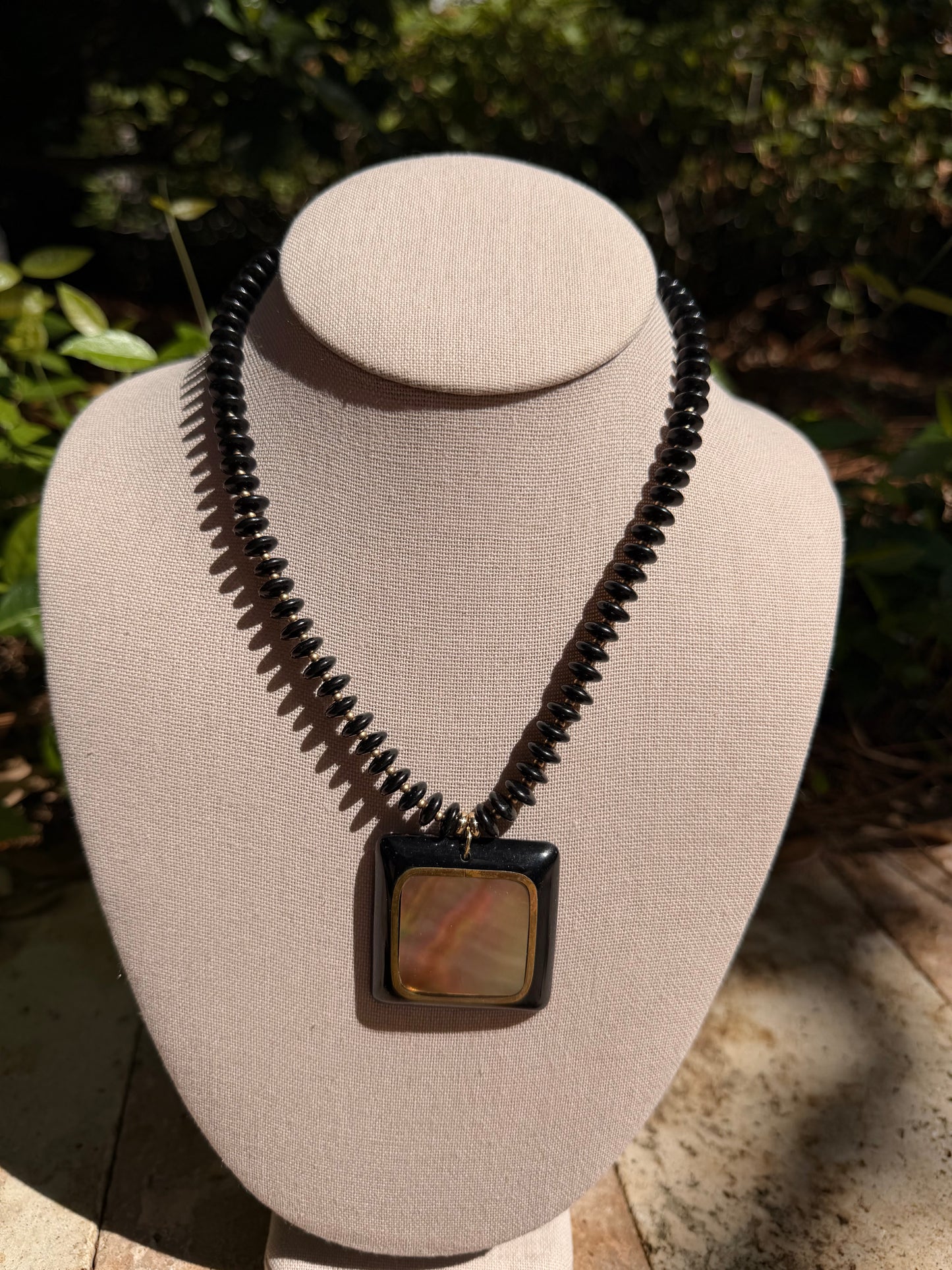 Flock: black saucer beads with a black and shell pendant