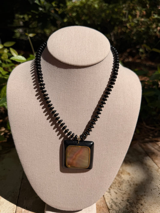Flock: black saucer beads with a black and shell pendant