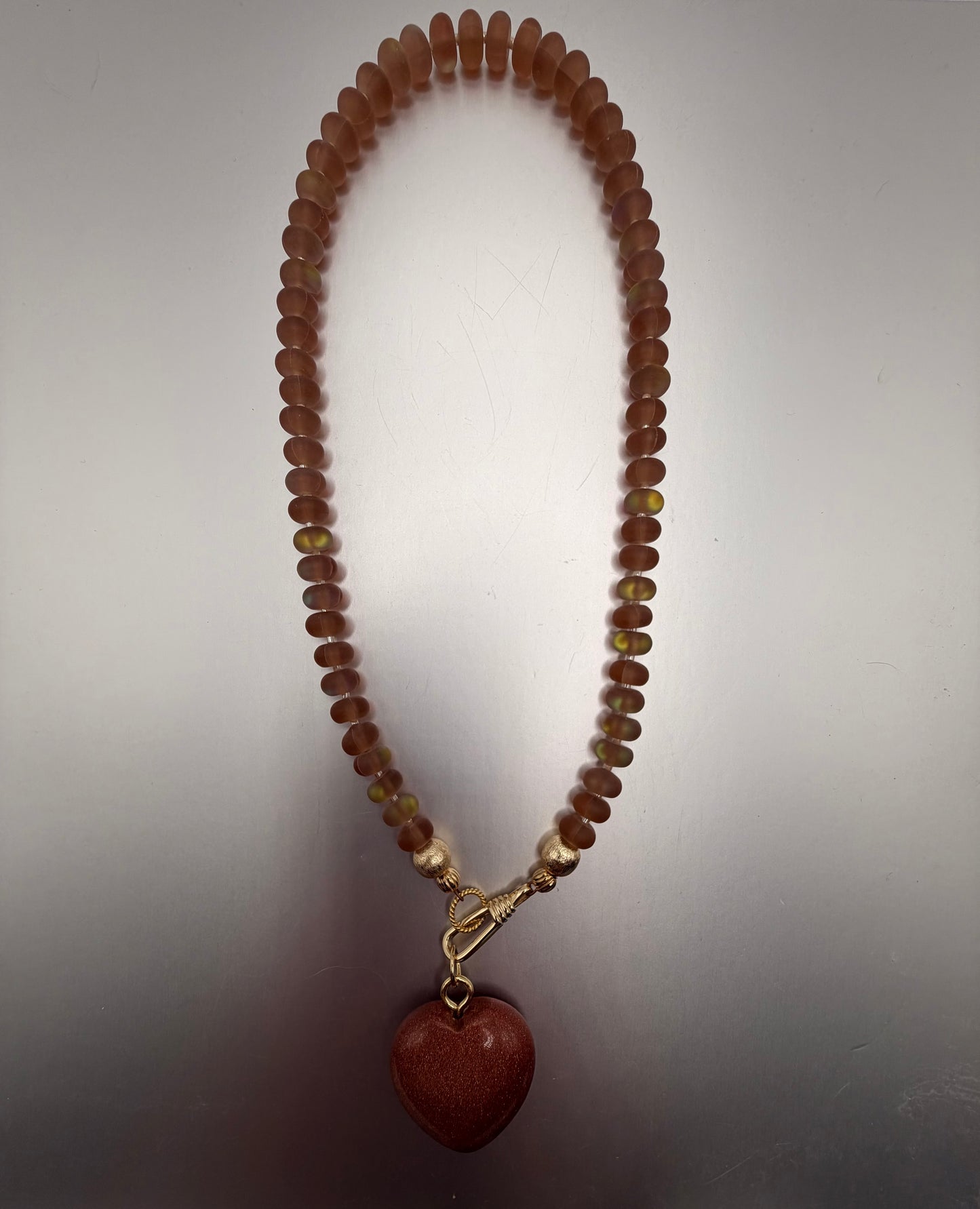 Flock: translucent caramel brown with a sparkly bronze heart pendant