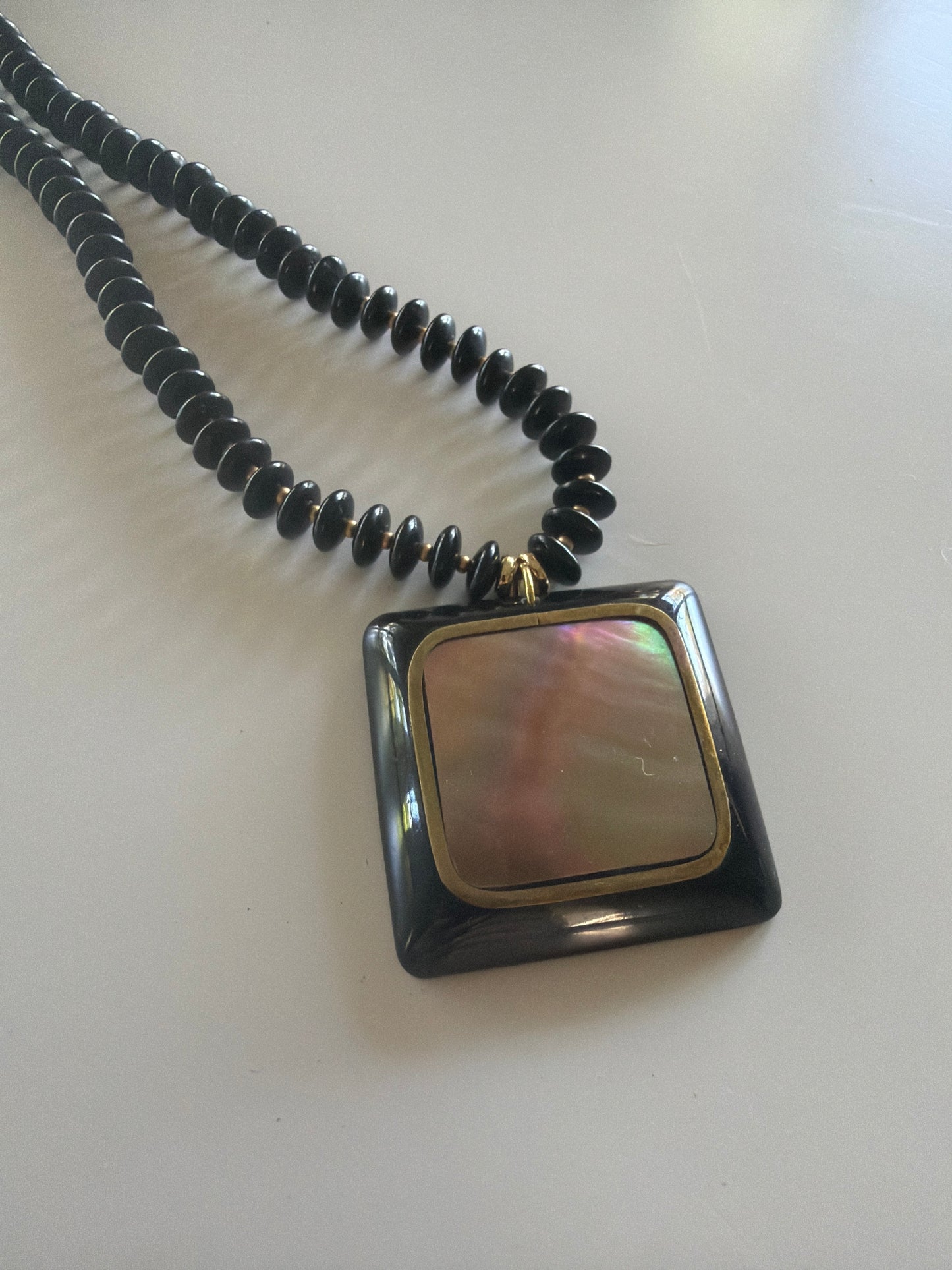 Flock: black saucer beads with a black and shell pendant