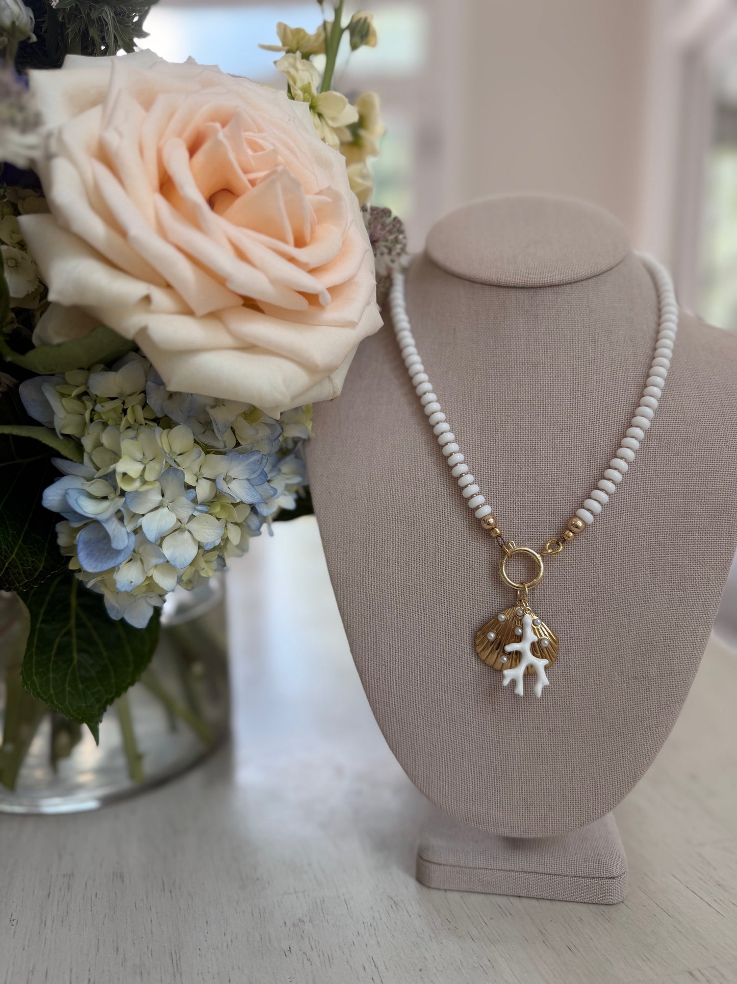 Beachy: white beads with a coral and shell charm