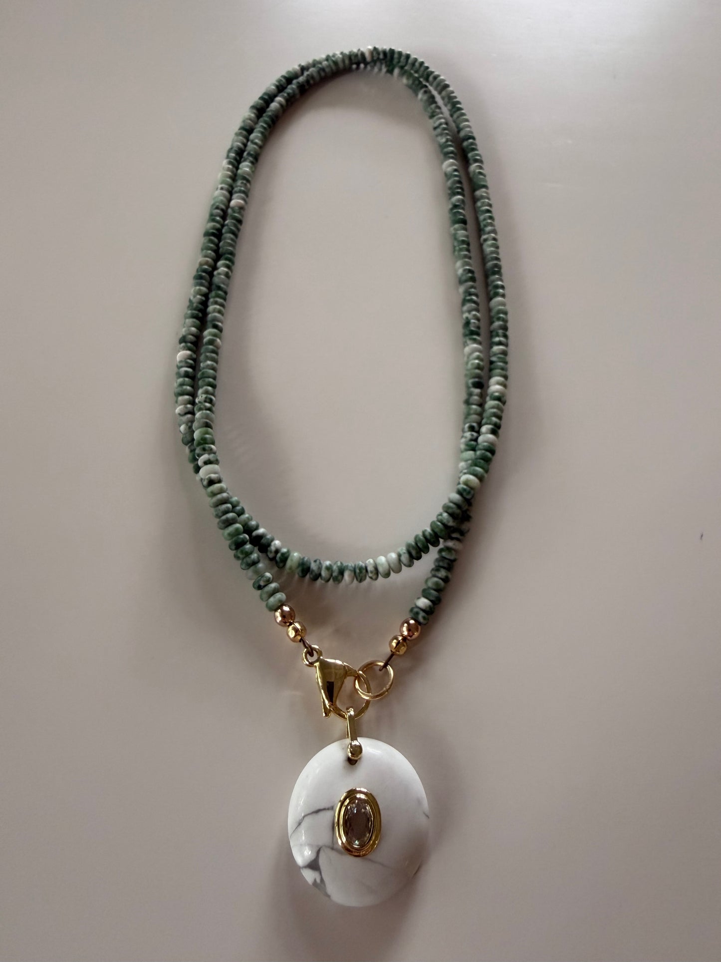 Double wrap: green and white beads with a round, white pendant